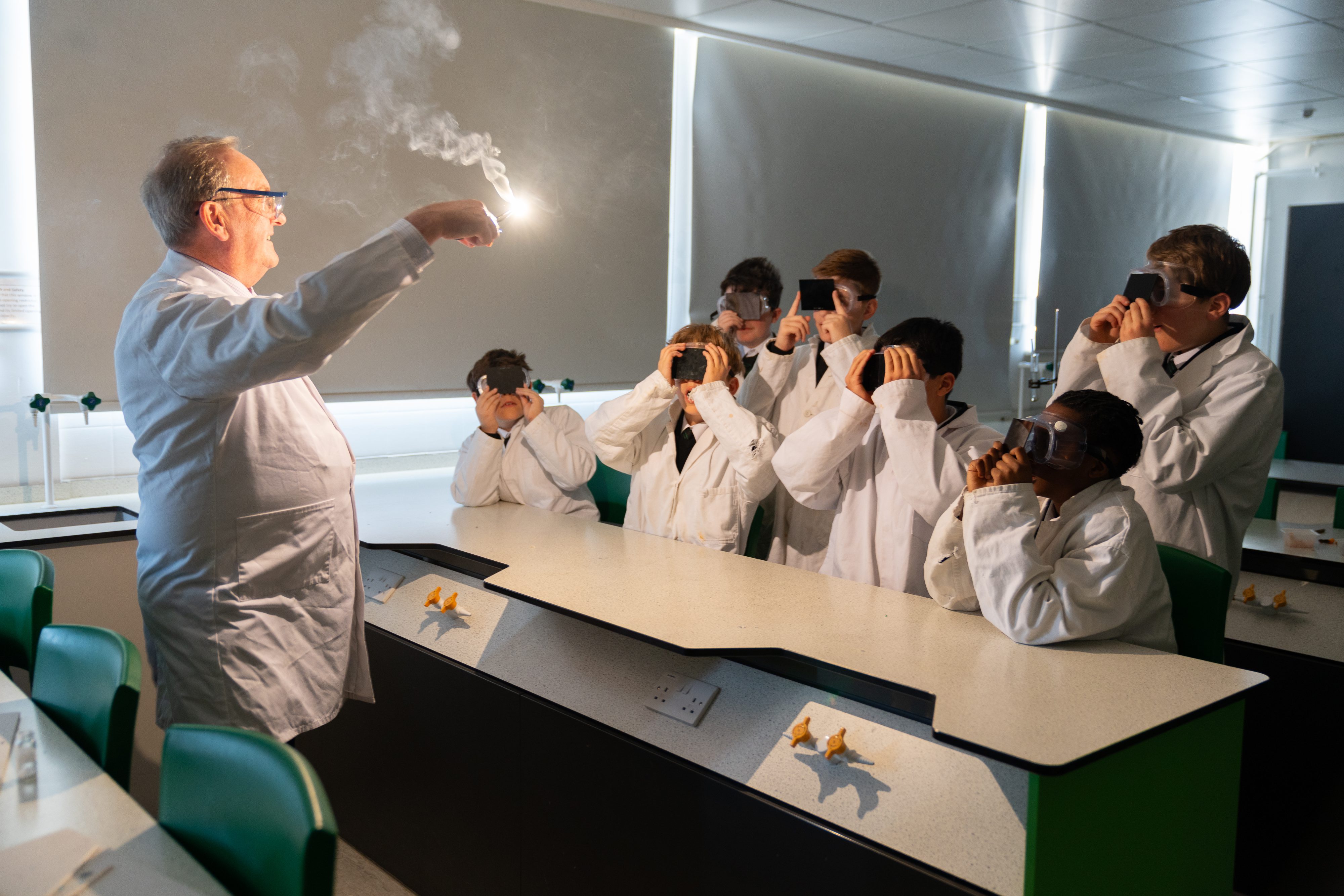 Science teacher demonstrating fire experiment in school classroom